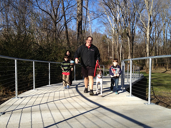 concrete boardwalk family and dog walker