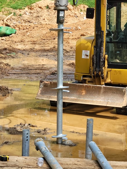 helical pier lead section being installed with small equipment